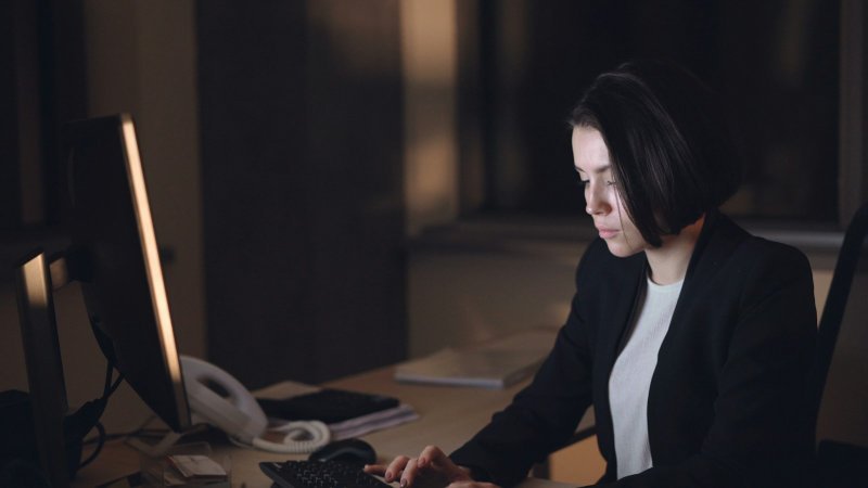 Professional working late while planning how to manage graduate school with unpredictable overtime