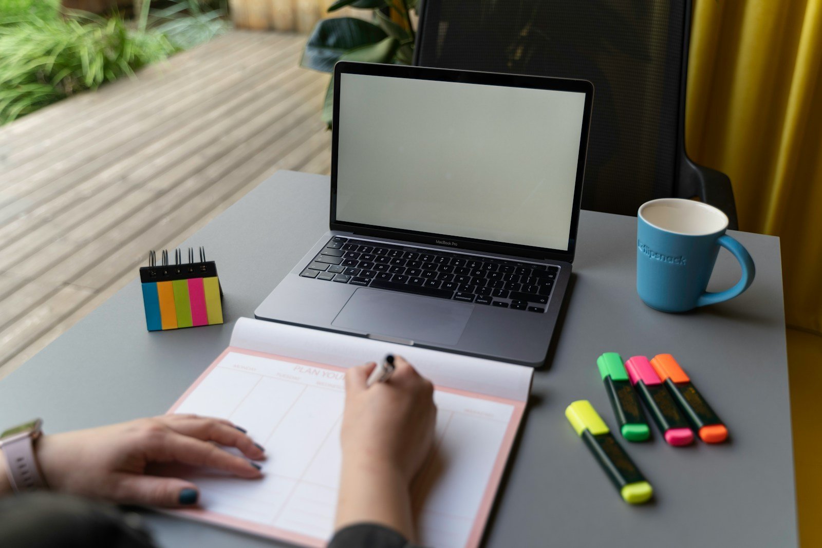 Working professional planning how to manage graduate school during peak work season beside a laptop and calendar
