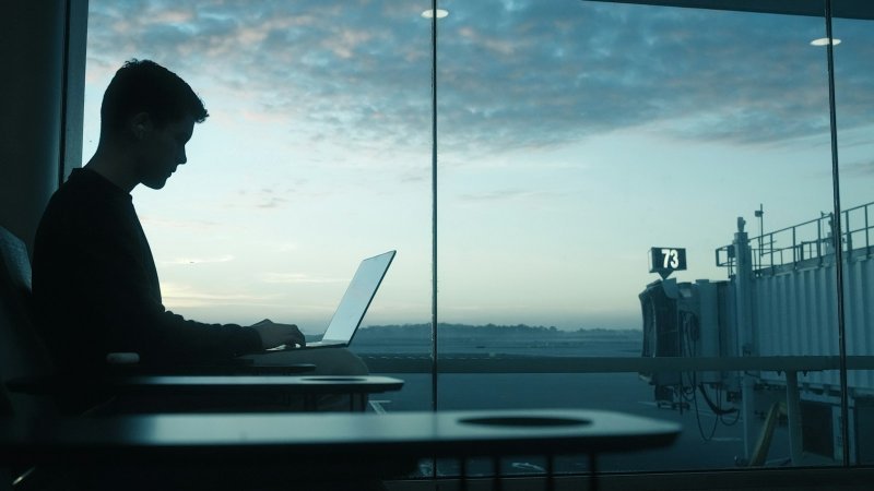 Business traveler planning how to manage graduate school during frequent business travel at an airport