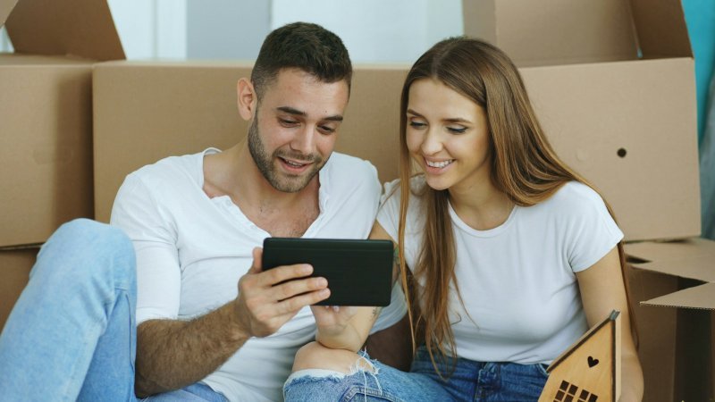 Couple with moving boxes planning how to manage graduate school while moving house